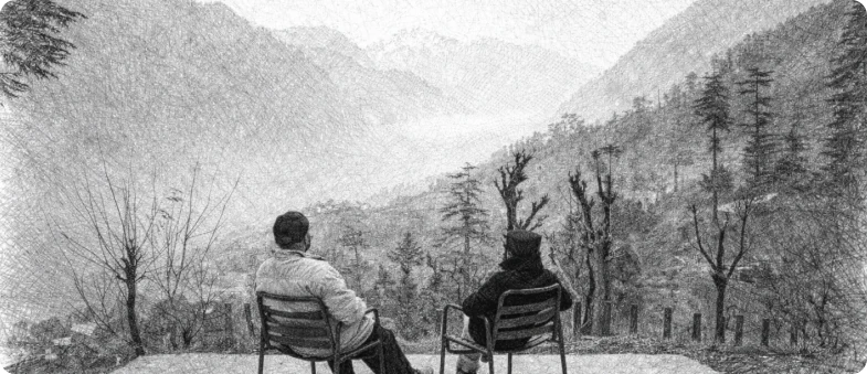 Two guests seated on a patio overlooking a misty mountain valley